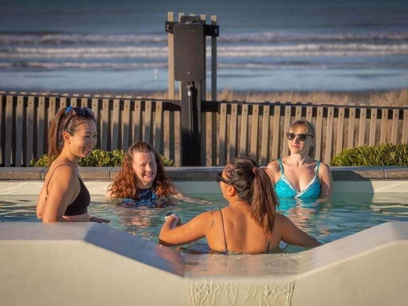 Group of ladies in pool looking out onto the beach